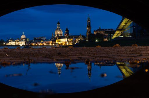 04 November 2019, Saxony, Dresden: The historical old town scenery with the dome of the Kunstakedemie (l-r), the Frauenkirche, the Ständehaus, the Hofkirche and the ICC is reflected under a bridge arch in a puddle. Photo: Robert Michael\/dpa-Zentralbild\/