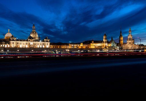 05 November 2019, Saxony, Dresden: Bicycle lights can be seen in front of the historic old town scenery with the Lipsius Building (l-r), the dome with the angel "Fama", the Frauenkirche, the Academy of Arts, the Ständehaus, the Hausmannsturm and the Hofkirche in the evening. (Shooting with long exposure) Photo: Robert Michael\/dpa-Zentralbild\/