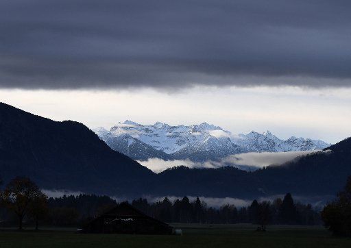 06 November 2019, Bavaria, Sindelsdorf: Dark clouds hang over the snow-covered mountains of the Karwendelgebirge. Photo: Angelika Warmuth\/
