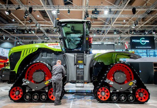 07 November 2019, Lower Saxony, Hanover: An employee is working on a tractor with rubber tracks at the Claas stand at the Agritechnica agricultural technology trade fair in Hanover. Around 2,800 exhibitors will be presenting their latest products at the international exhibition for agricultural machinery from 10 to 16 November. Photo: Hauke-Christian Dittrich\/