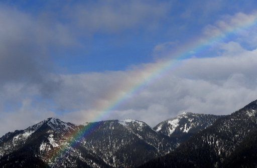 31 January 2020, Bavaria, Garmisch-Partenkirchen: A rainbow can be seen above the summit of the Hohe Ziegspitz. Photo: Angelika Warmuth\/