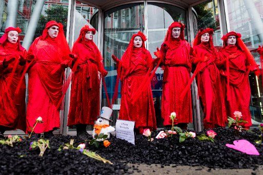 14 February 2020, North Rhine-Westphalia, Duesseldorf: Activists of Extinction Rebellion demonstrate in front of Uniper headquarters. Various activists have dumped coal in front of the energy company\