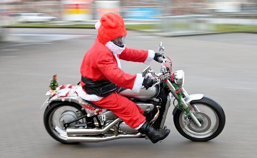 21 December 2019, Schleswig-Holstein, Kiel: A motorcyclist dressed up for Christmas starts for the "X-Mas Ride 2019". For the sixth time already, more than one hundred motorcyclists will tour Kiel on the last weekend of Advent to collect donations. This year, the children\