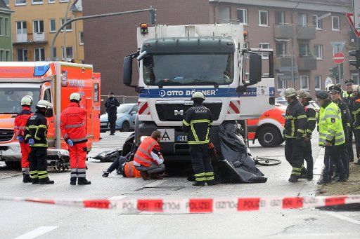 13 January 2020, Hamburg: Emergency services are on duty at the scene of a fatal traffic accident. In a traffic accident in Hamburg-Wandsbek, a cyclist was hit by a garbage truck and fatally injured. Photo: Bodo Marks\/