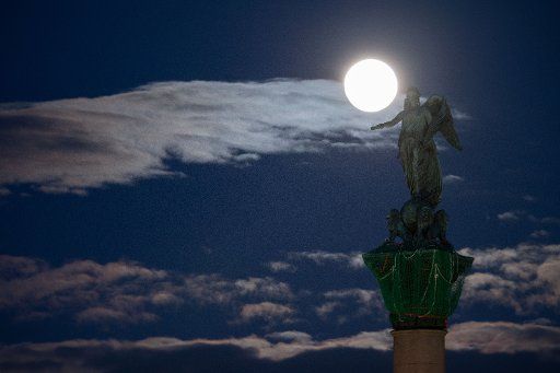 09 March 2020, Baden-Wuerttemberg, Stuttgart: The moon can be seen behind the statue of the Roman goddess Concordia, who is enthroned on the Jubilee Column above the Schlossplatz. Photo: Marijan Murat\/