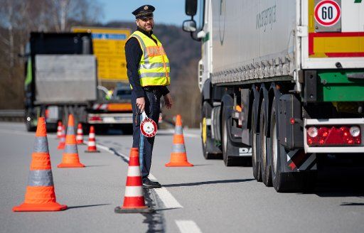 16 March 2020, Bavaria, Kirchdorf Am Inn: Police officers are standing at a checkpoint on the B12 federal road near Kirchdorf am Inn on the border with Austria. Germany has decided to close its borders at least partially because of the corona virus. Photo: Sven Hoppe\/