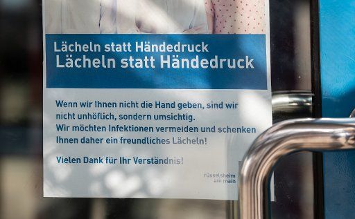 17 March 2020, Hessen, Rüsselsheim: At an authority hangs a poster with the instruction to avoid shaking hands. Photo: Andreas Arnold\/