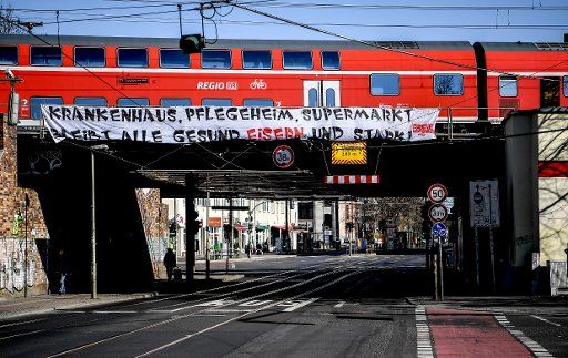 23 March 2020, Berlin: At the Köpenick S-Bahn station there is a banner with the inscription "Krankenhaus, Pflegeheim, Supermarkt bleibt alle gesund, Eisern und stark! On 22.03.2020, the federal and state governments had decided on far-reaching measures to prevent a rapid spread of the corona virus. Photo: Britta Pedersen\/dpa-Zentralbild\/