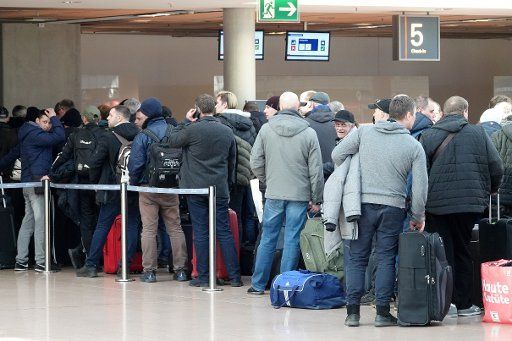 23 March 2020, Hamburg: People stand next to each other and behind each other at a check-in counter for a flight to Vilnius (Lithuania). In order to slow down the spread of the corona virus, the federal government has further considerably restricted public life. Photo: Bodo Marks\/