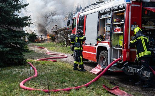 31 March 2020, Brandenburg, Potsdam: Firefighters extinguish a burning arbour in Potsdam Bornstedt. Photo: Christophe Gateau\/