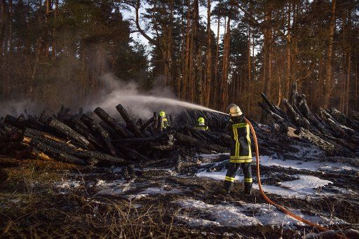 05 April 2020, Brandenburg, Wandlitz: The fire brigade extinguishes about 10,000 cubic metres of burning logs near the L100 between Schönwalde and Basdorf (municipality of Wandlitz) in the Barnim district. For reasons as yet unknown, the logs caught fire. The fire brigades of the surrounding communities were on a large scale. Photo: Jörg Carstensen\/