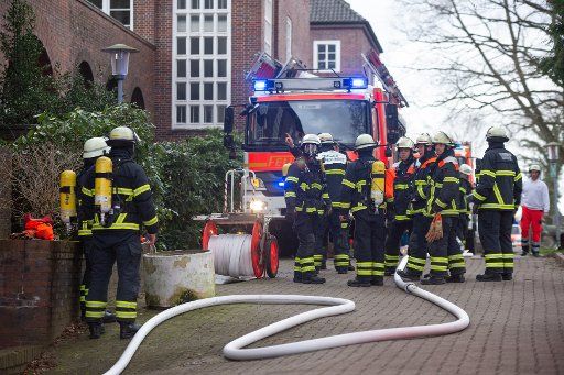 18 February 2020, Hamburg: Emergency personnel with breathing apparatus and fire brigade vehicles are standing at a retirement home. According to the fire brigade, a man has died despite reanimation after an apartment fire in Groß-Borstel. Photo: Jonas Walzberg\/
