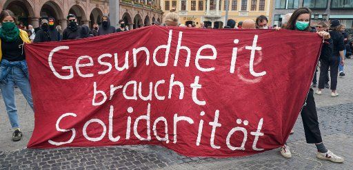 30 May 2020, Saxony, Leipzig: Participants of the planned rally and demonstration "Solidarity instead of right-wing agitation" demonstrate with a banner with the inscription "Health needs solidarity" on the market place of Leipzig. Photo: Peter Endig\/dpa-Zentralbild\/