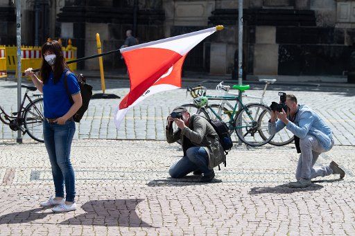 08 June 2020, Saxony, Dresden: Journalists take pictures of a participant wearing a mouthguard, who is shouldering a flag at a student rally on Theaterplatz. At the rally, attention was drawn to the inadequate aid measures for students in financial hardship due to the Corona crisis. Photo: Sebastian Kahnert\/dpa-Zentralbild\/