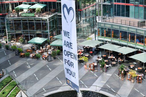 25 June 2020, Berlin: "We are open for you" is written on a banner in the Sony Center am Potsdamer Platz. Photo: Jens Kalaene\/dpa-Zentralbild