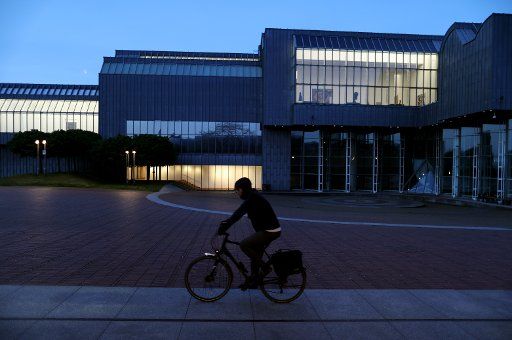 15 April 2020, North Rhine-Westphalia, Cologne: A man rides his bicycle past the Museum Ludwig in the morning. Photo: Oliver Berg\/