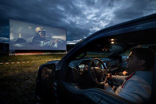 28 April 2020, Thuringia, Hohenfelden: Cars will be standing in front of the big screen at the Hohenfelden reservoir during the test run before a film is shown here every evening in the drive-in cinema with a capacity of 150 cars from 29.4.2020. In Thuringia drive-in cinemas are again permitted, as the rules for social distance can be safely observed in one\