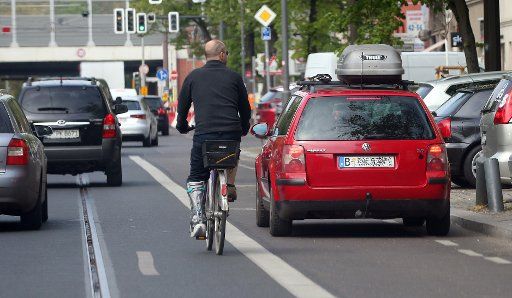 29 April 2020, Berlin: A passenger car is parked on a cycle path in the Köpenick district and obstructs cyclists who have to avoid the vehicle. Despite the new list of fines, cycle paths are still being blocked. Photo: Wolfgang Kumm\/dpa - ATTENTION: The license plate of the vehicle was pixelated for legal