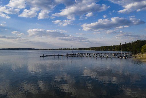 29 April 2020, Brandenburg, Diensdorf: A jetty juts out into the Scharmützelsee near Diensdorf. It is the second largest natural lake in Brandenburg. During a visit to the then still small manor villages Saarow and Pieskow in 1881, the poet Theodor Fontane called the lake Märkisches Meer, a name that is still used today in tourism advertising. (Recording with a threat) Photo: Paul Zinken\/dpa-Zentralbild\/