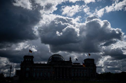 05 May 2020, Berlin: The sun is hiding behind dark clouds above the Reichstag, the seat of the German Bundestag. A mix of sun and clouds as well as partly short thunderstorms - according to the German Weather Service (DWD), Berliners and Brandenburgers should continue to prepare for this in the next few days. Photo: Michael Kappeler\/