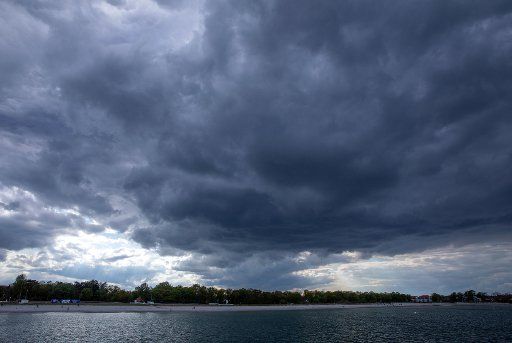17 May 2020, Mecklenburg-Western Pomerania, Bolttenhagen: Dark rain clouds move over the Baltic Sea beach in changeable weather. Photo: Jens Büttner\/dpa-Zentralbild\/