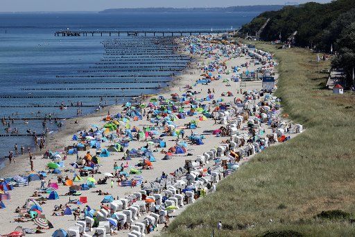 06 August 2020, Mecklenburg-Western Pomerania, Kühlungsborn: Holidaymakers have gathered at the Baltic Sea beach, from the 60-metre high Ferris wheel you have a good view of the hustle and bustle. Midsummer temperatures bring new records for visitors to the coasts. Photo: Bernd Wüstneck\/dpa-Zentralbild\/dpa