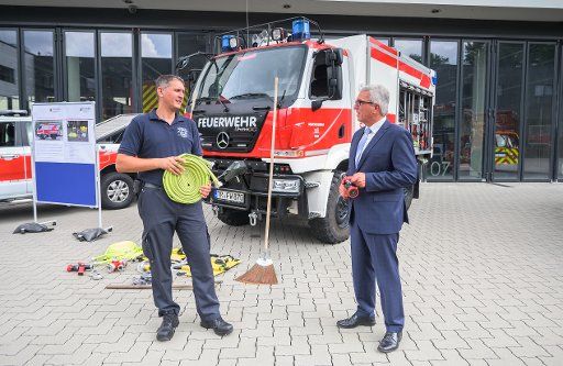 17 August 2020, Rhineland-Palatinate, Mainz: Christian Feld (l), Brandamtmann Professional Fire Brigade Trier, talks to Roger Lewentz (SPD), Minister of the Interior of Rhineland-Palatinate, about the equipment on a special vehicle. At a press event, the Minister of the Interior of Rhineland-Palatinate will inform about the subsidized procurement of special vehicles for fire brigades with state funds. In the future, it should be possible to react better to heavy rainfall events and forest fires off-road with special vehicles. Photo: Andreas Arnold\/dpa