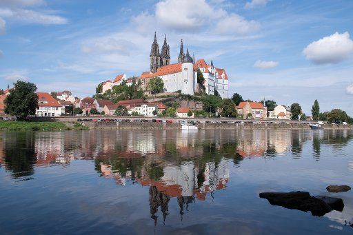 24 August 2020, Saxony, Meißen: The Albrechtsburg with the cathedral is reflected in the Elbe. Albrechtsburg Castle, built in the 15th century, is considered the first castle in German building history. The late gothic building is enthroned high above the Elbe. In 1710, Augustus the Strong had the first European porcelain manufactory established here. Photo: Sebastian Kahnert\/dpa-Zentralbild\/dpa