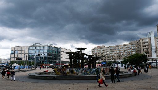 27 August 2020, Berlin: Dark clouds can be seen in the sky above Alexanderplatz with the fountain of international friendship. Photo: Jens Kalaene\/dpa-Zentralbild\/dpa