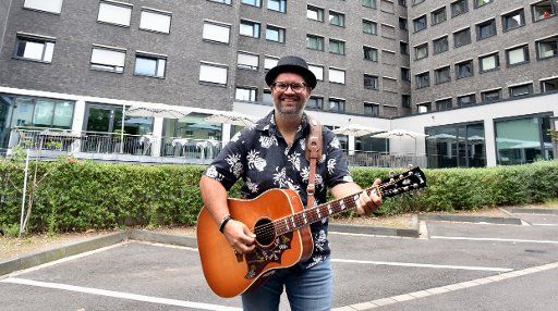 26 July 2020, North Rhine-Westphalia, Cologne: Musician Björn Heuser poses with guitar at the presentation of the sing-along concert on 31.07.2020 at the Stadthotel am Römerturm. A total of 104 guests can participate in the concert in their booked double rooms Photo: Horst Galuschka\/dpa