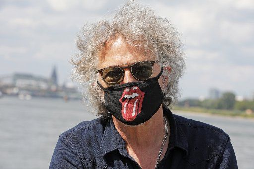 28 July 2020, North Rhine-Westphalia, Cologne: The musician and singer Wolfgang Niedecken stands on the Rhine with a mouthguard bearing the tongue logo of the Rolling Stones. (To dpa: "Freedom in Corona times: Taken early, melted away fast?") Photo: Oliver Berg\/dpa