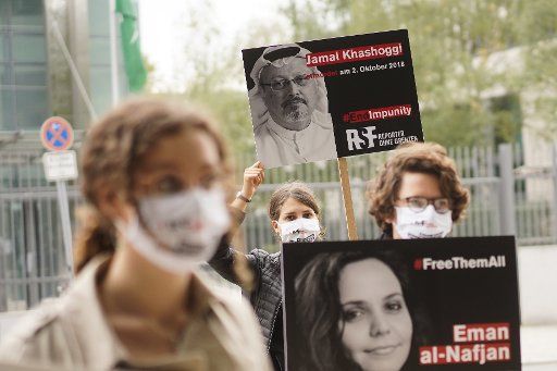 02 October 2020, Berlin: Activists of "Reporters Without Borders" stand at a vigil in front of the Saudi Arabian Embassy to commemorate the second anniversary of the murder of the Saudi Arabian exile journalist Jamal Khashoggi (pictured on the poster behind). Photo: Jörg Carstensen\/dpa