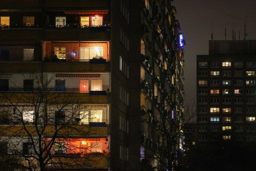 17 December 2020, Saxony, Leipzig: Many windows of an apartment block in the Grünau district are lit up. Saxony went into lockdown two days before the rest of Germany due to the high number of Corona cases. Photo: Jan Woitas\/dpa-Zentralbild\/dpa