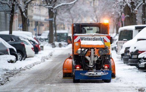 06 January 2021, Bavaria, Munich: A snow removal vehicle clears a snow-covered street in a residential area. Photo: Sven Hoppe\/dpa