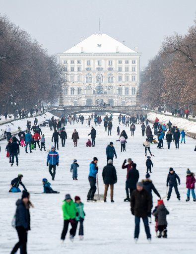 10 January 2021, Bavaria, Munich: Excursionists cavort on the frozen Nymphenburg Canal in front of Nymphenburg Palace. From 11.01.2020 stricter rules apply because of the Corona pandemic. Photo: Matthias Balk\/dpa