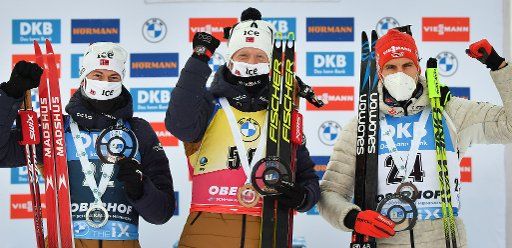 13 January 2021, Thuringia, Oberhof: Biathlon: World Cup, sprint 10 km, men, award ceremony. Sturla Holm Laegreid (l) and Johannes Thingnes Boe (M), both from Norway as well as Arnd Peiffer (r) from Germany are on the podium. Boe wins ahead of Laegreid and Peiffer. Photo: Martin Schutt\/dpa-Zentralbild\/dpa