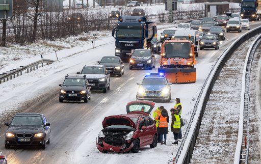 14 January 2021, Bavaria, Munich: A car is parked on the snow-covered A94 motorway after an accident. Photo: Peter Kneffel\/dpa