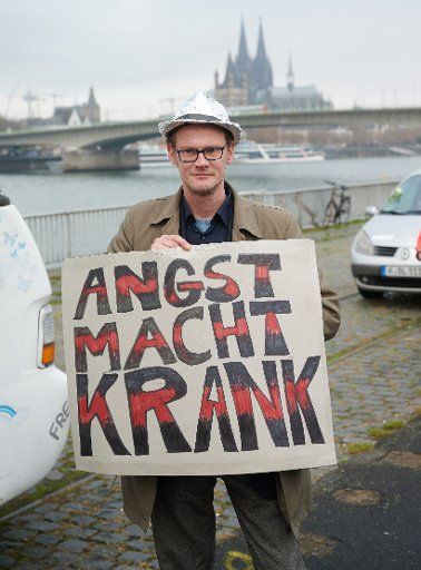 11 November 2020, North Rhine-Westphalia, Cologne: A participant in a demonstration against corona protection measures wears a sign with the inscription "Angst macht krank". Photo: Henning Kaiser\/dpa