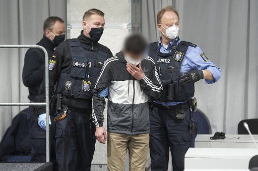 20 November 2020, Hessen, Limburg: The accused is led into the courtroom, which is provisionally set up in a marquee. He is accused of attempted murder, among other things. He is accused of having hijacked a truck in Limburg in October 2019 and then deliberately used it to hit cars standing in front of a traffic light. 18 people were injured. Photo: Thomas Frey\/dpa Pool\/dpa - ATTENTION: The defendant was pixelated by order of the court