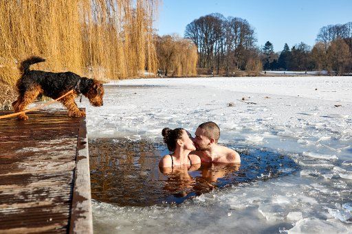 dpatop - 14 February 2021, Hamburg: Kristyna Amanatidu and Ondrej Keves kiss while ice bathing in the City Park Lake on Valentine\
