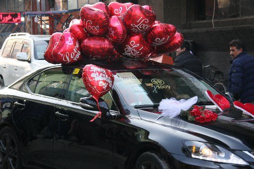 14 February 2021, Afghanistan, Kabul: Red balloons are tied to the roof of a car in the Afghan capital. Photo: Hesam Hesamuddin\/dpa