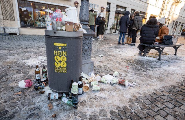 13 February 2021, Bavaria, Munich: A full trash can stands on a popular square in the Haidhausen district. Photo: Peter Kneffel\/dpa