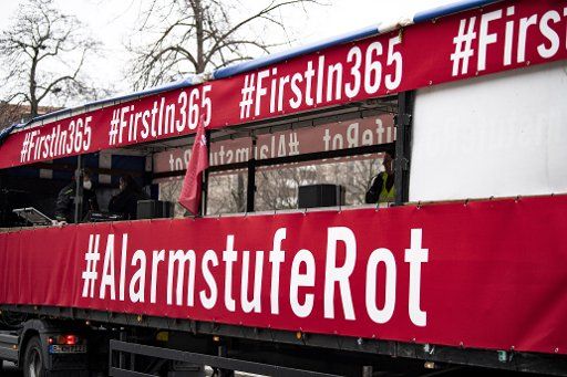 28 February 2021, Berlin: A truck carrying banners reading "#FirstInn365" and "#AlertRed" drives through town in the demonstration with a motorcade of event industry workers. Photo: Fabian Sommer\/dpa