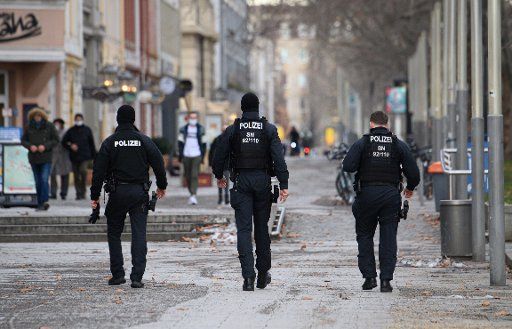 20 January 2021, Saxony, Dresden: Police officers walk down Main Street to check for compliance with the Corona Protection Ordinance. Photo: Robert Michael\/dpa-Zentralbild\/dpa