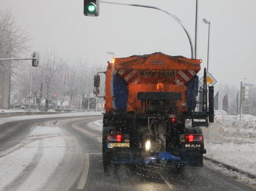 23 January 2021, Thuringia, Gera: A vehicle of the winter service drives through Theaterstraße. It has been snowing again in Thuringia since the morning hours. Photo: Bodo Schackow\/dpa-Zentralbild\/dpa