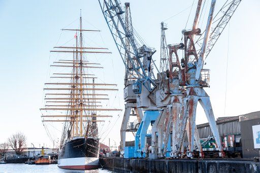 25 December 2020, Hamburg: The four-masted barque Peking lies in front of historic harbour cranes on the quay of the Hamburg Harbour Museum. Photo: Markus Scholz\/dpa