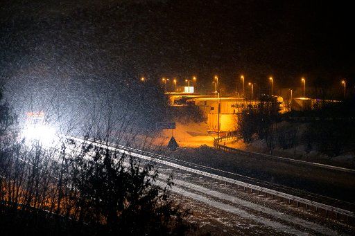 08 February 2021, Lower Saxony, Himbergen: The headlights of a truck illuminate the driving snow above the partially cleared A30 motorway. Photo: Jonas Walzberg\/dpa