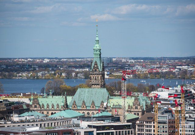 24 April 2021, Hamburg: The town hall rises above the roofs of the city centre . Photo: Daniel Bockwoldt\/dpa