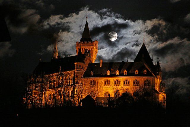 26 April 2021, Saxony-Anhalt, Wernigerode: Clouds cover the full moon over the Wernigerode castle. On 27 April 2021 there is a so-called "supermoon". Then the distance between moon and earth is smaller than usual. Photo: Matthias Bein\/dpa-Zentralbild\/ZB