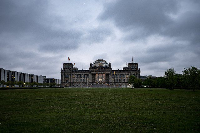 12 May 2021, Berlin: Dark clouds hang over the Reichstag building of the Bundestag in the early morning. Photo: Fabian Sommer\/dpa